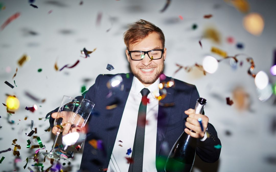 man holding champagne and glass while having fun at corporate event