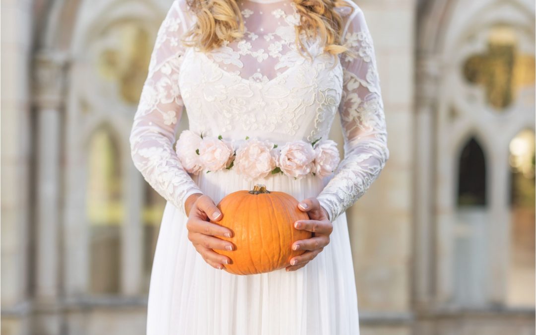 Bride holding a pumpkin during her halloween wedding