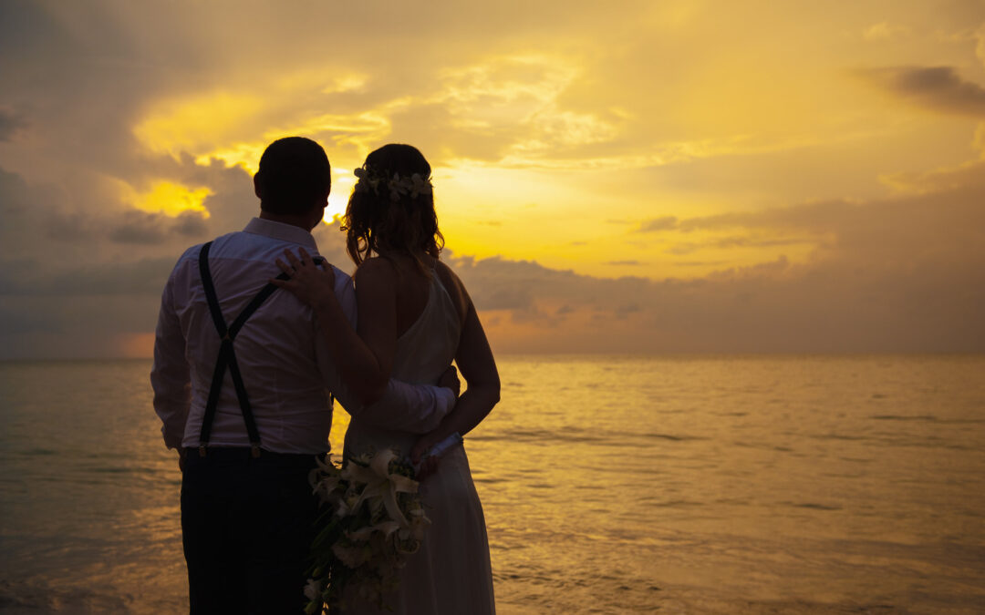 happy married coupled looking at the horizon sunset on the beach after renewing vowels